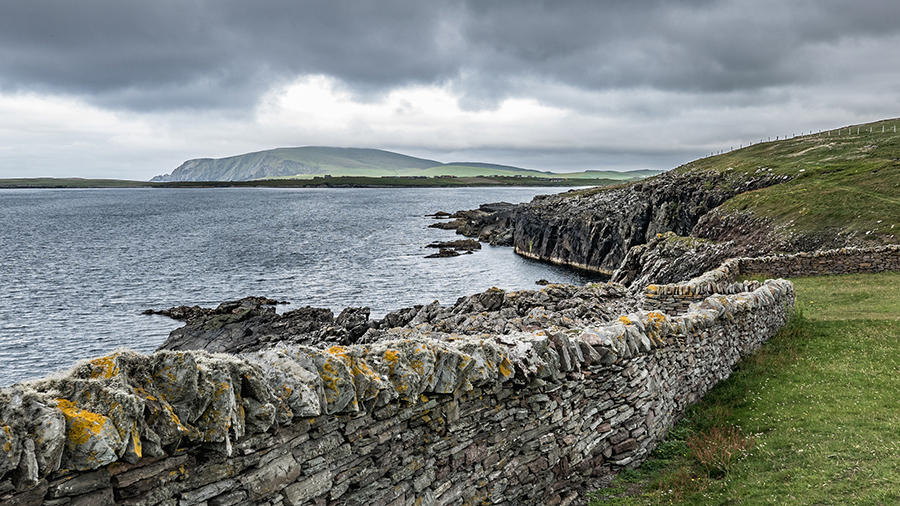 Dry Stone Wall built on the edge of land along the rugged cliffs of the Sumburgh Head shoreline. This wall serves to protect walkers and shelter them a bit from fierce sea winds.